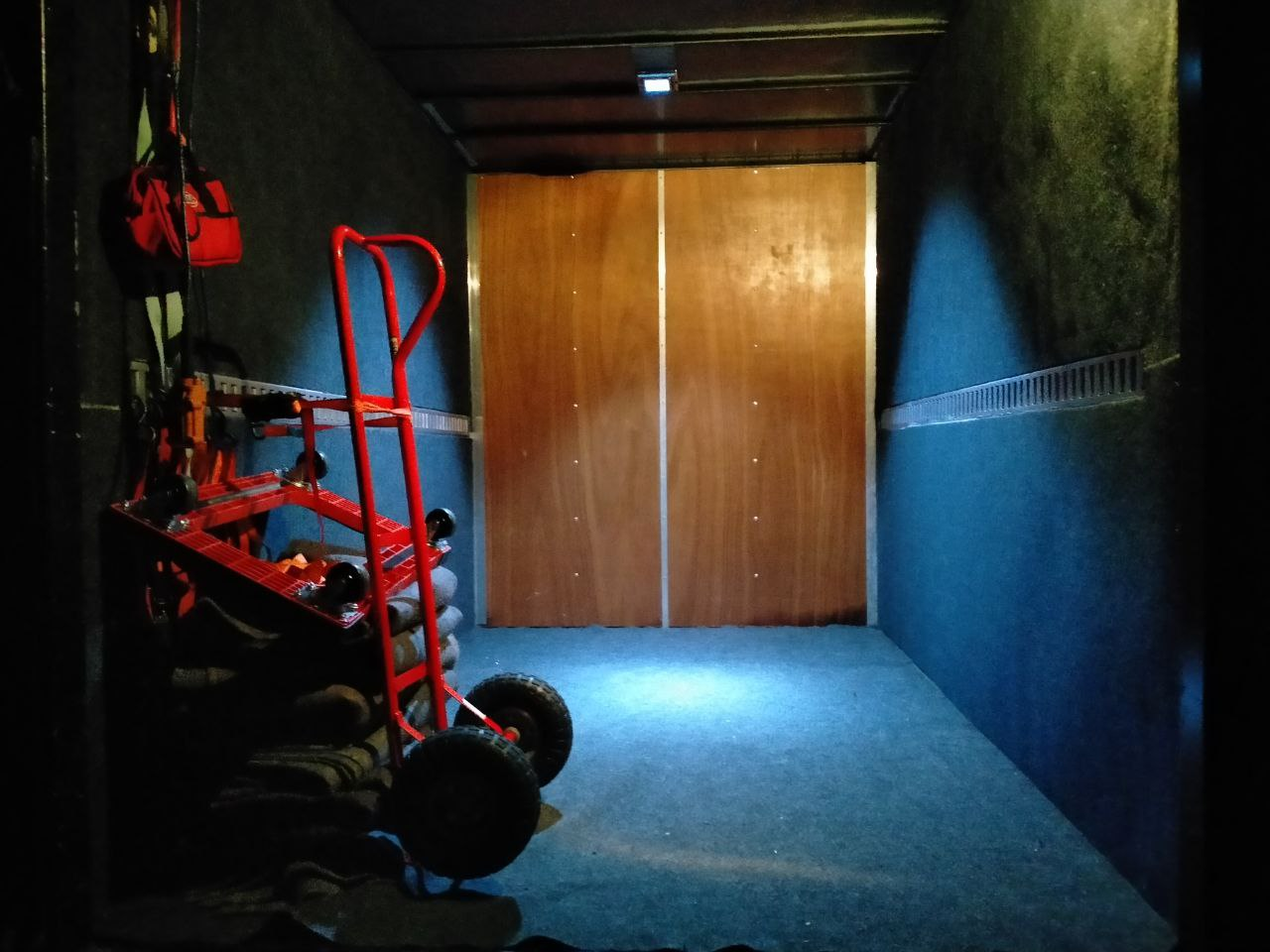 Inside view of a clean and tidy moving truck at night with down lighting inside lighting up the interior